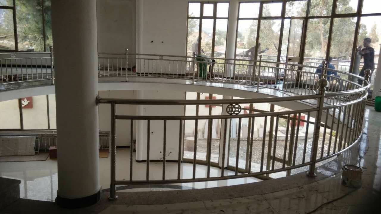 Curved polished stainless handrail on an interior staircase